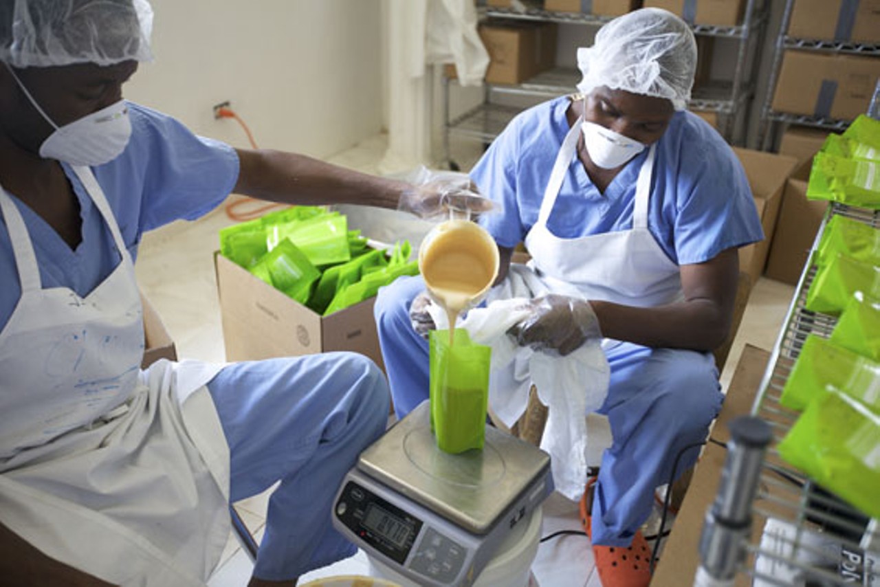 Workers pour medika mamba into packets.