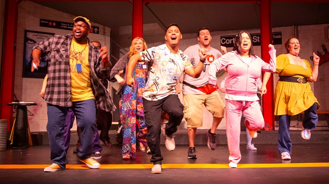 The cast of Godspell dances onstage.
