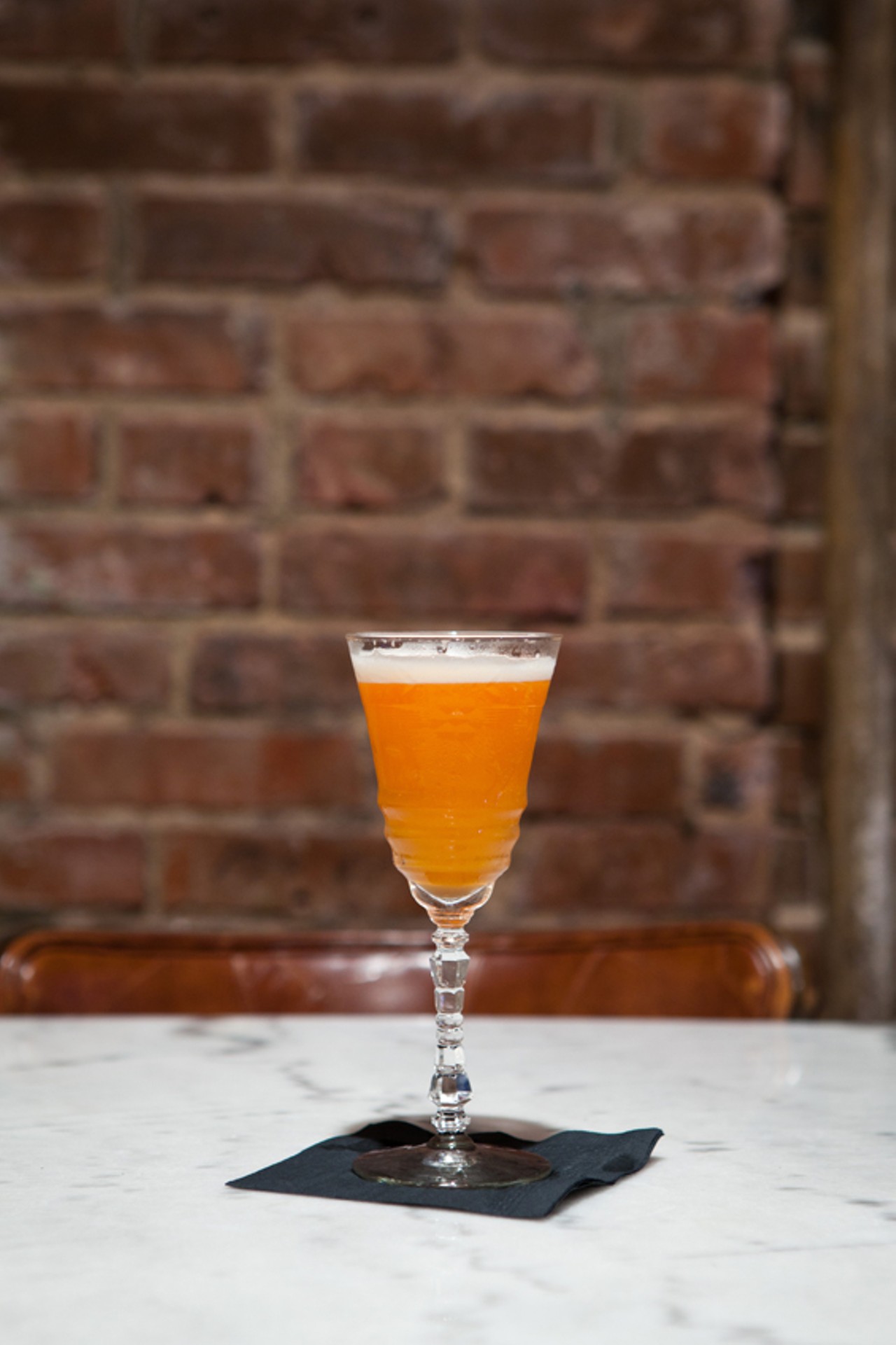 The Subtle Hustle cocktail, made with Aperol, Cocchi Americano, lemon juice, passion fruit, and champagne.