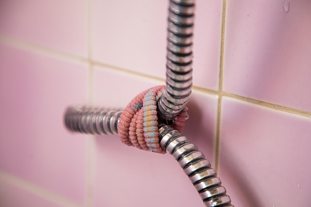 A shower hose is crimped closed to prevent water from running inside one apartment.