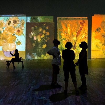 The still life paintings of flowers are projected onto the walls.