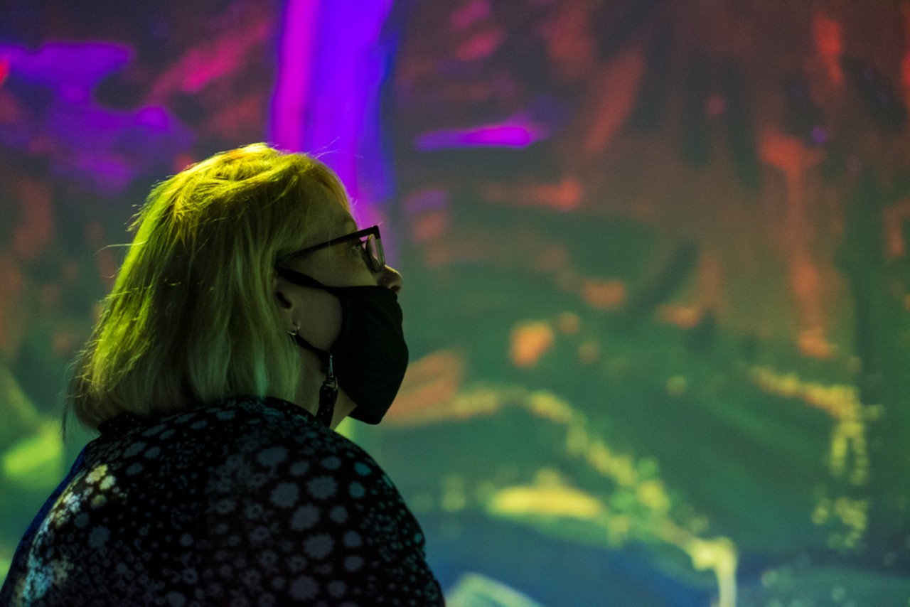 A woman watches the projections.