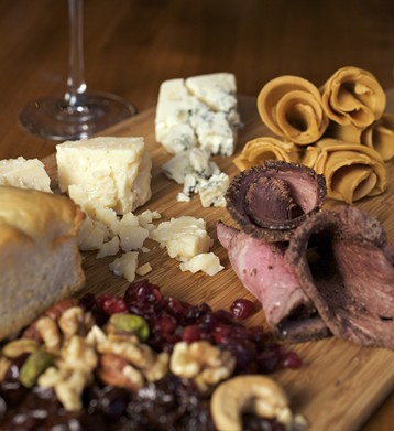 One page of the menu is a four-column chart where you select, a la carte, a cheese and charcuterie plate. Shown here is a richly nutty and sweet Norwegian cheese (on top right), Gjetost. Then, going clockwise, is a dry rubbed smoked New York strip, dried fruits and nuts that accompany every a la carte cheese and charcuterie plate along with the bread. Then there is the Jasper Hill Cellar Aged, which is a buttery cheese with a clean, tangy finish from Vermont. And last, a Rogue Creamery Smoky Blue from Oregon. It has a hint of smoke, which gives way to sweet and salty.