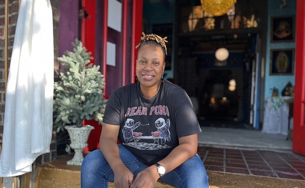 Co-owner LaTosha Baker sits on the golden steps of the Drip Community Coffee House.