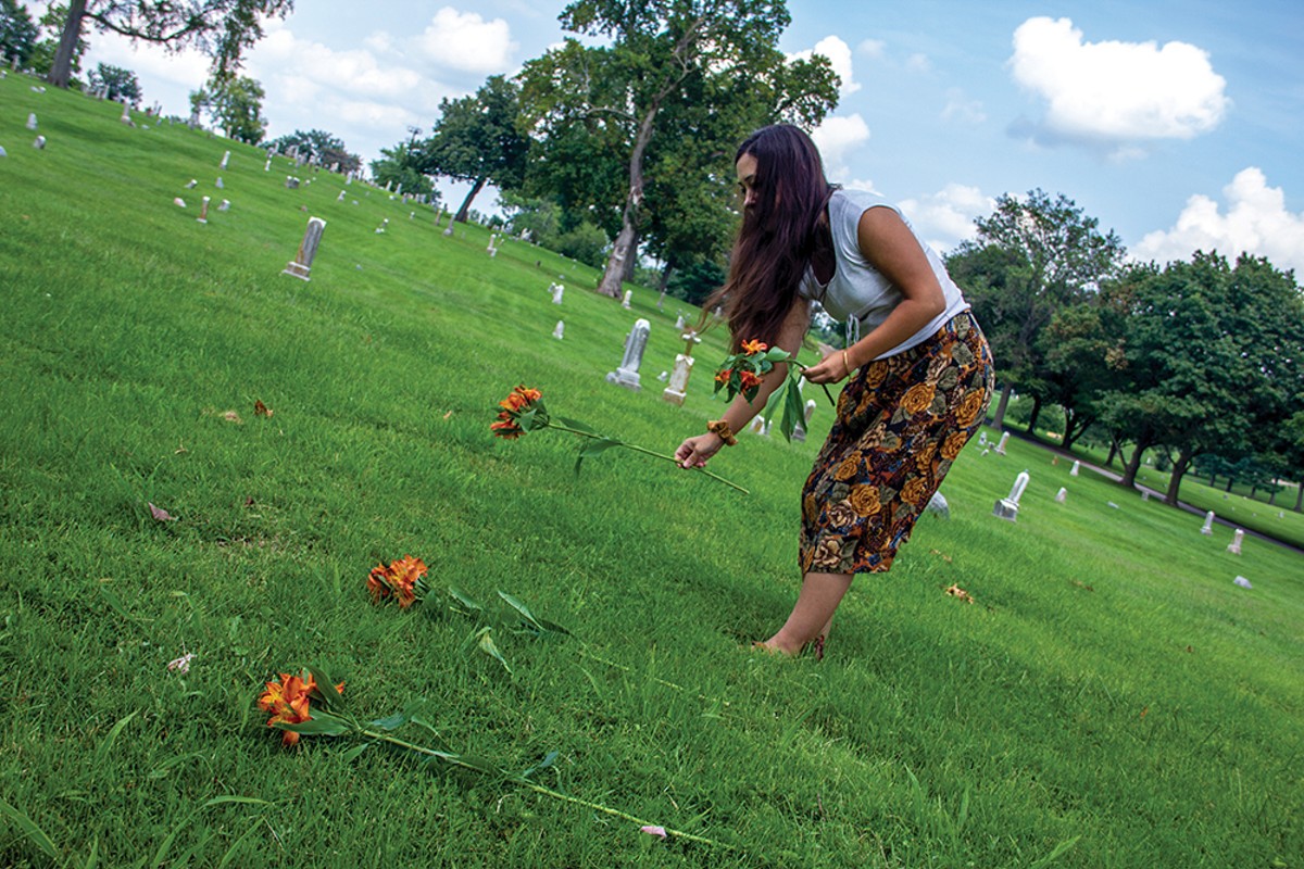 Janna Añonuevo Langholz places flowers at the graves of tribal members imported for the 1904 World's Fair's "Philippine Village."
