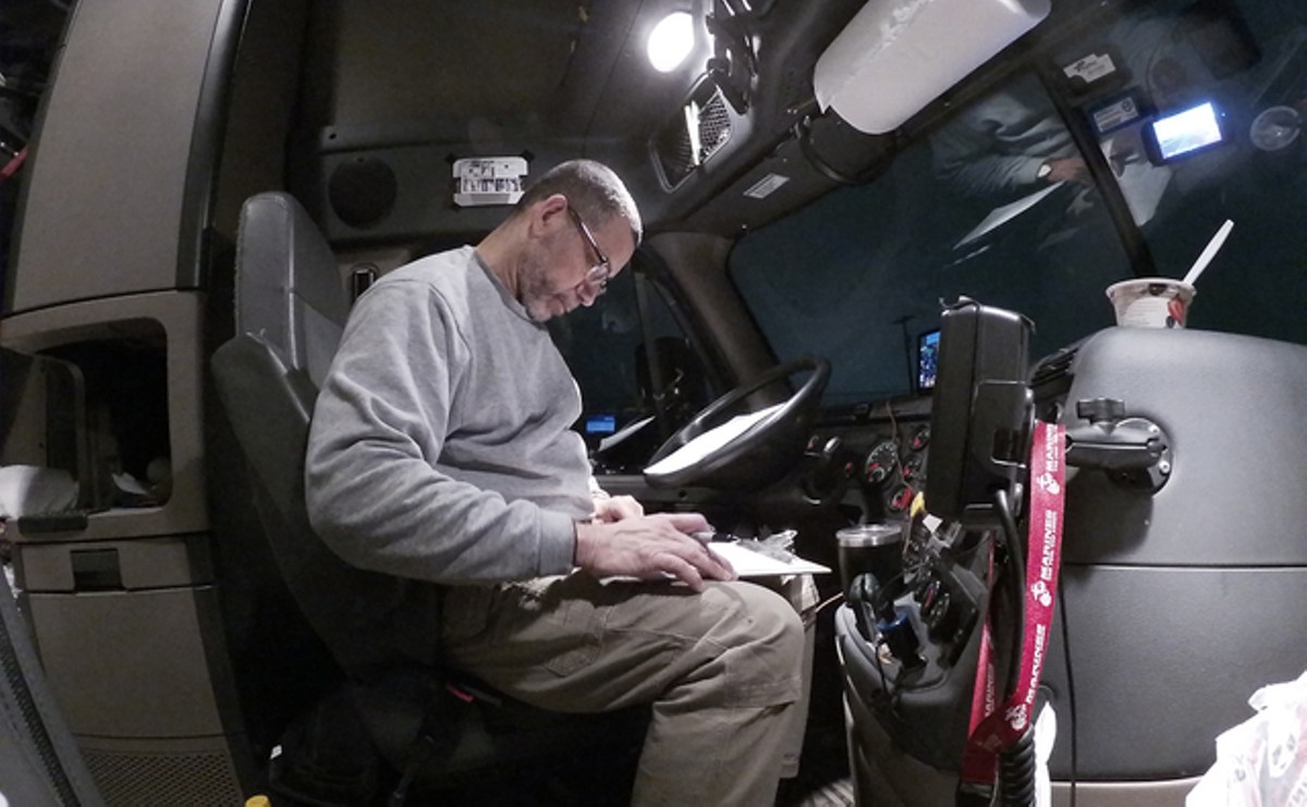 Long-haul truck driver Chet Gordon completes his load paperwork at 6:20 a.m. after a 3:30 a.m. Tyson meats load delivery to the Walmart Distribution Center in Pottsville, Pennsylvania, on March 17.