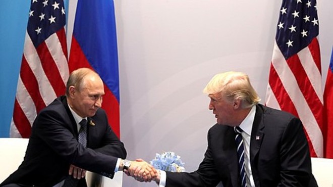 Vladmir Putin and Donald Trump shake hands in 2017.