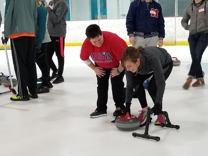 A "Learn to Curl" participant prepares to throw the 42-pound granite curling stone down the ice. - ALLISON BABKA