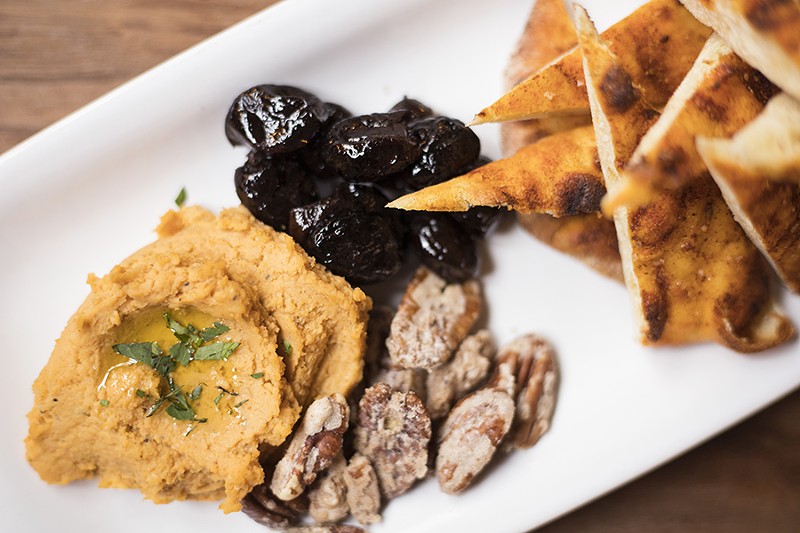 The spiced flatbread combines olives, candied pecans, honey, spicy hummus and preserved lemon. - MABEL SUEN