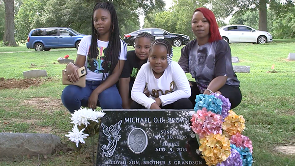 Michael Brown's family visits his resting place. - JASON POLLOCK