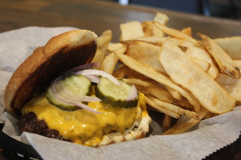 Twisted Roots' burger comes topped with pickle, onion and your choice of cheese and sauce. - SARAH FENSKE