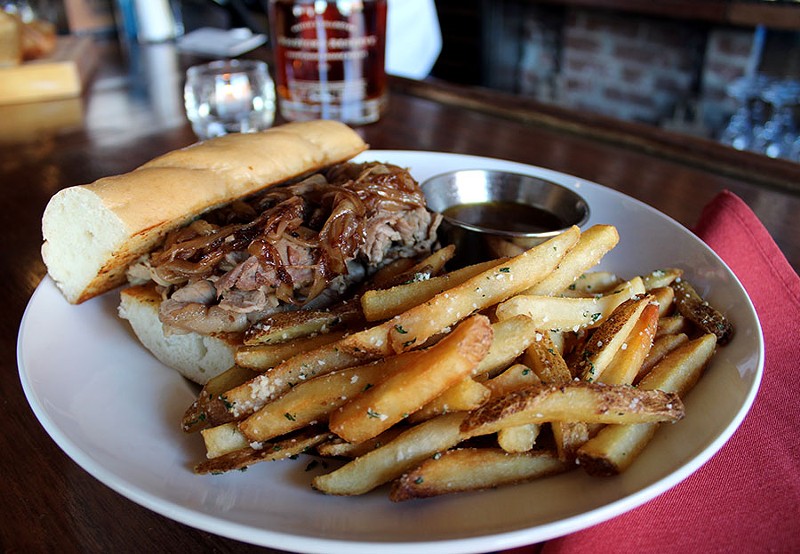 From the bar menu, the shaved prime rib sandwich with au jus and balsamic onions served with fries costs $12.99. - LEXIE MILLER