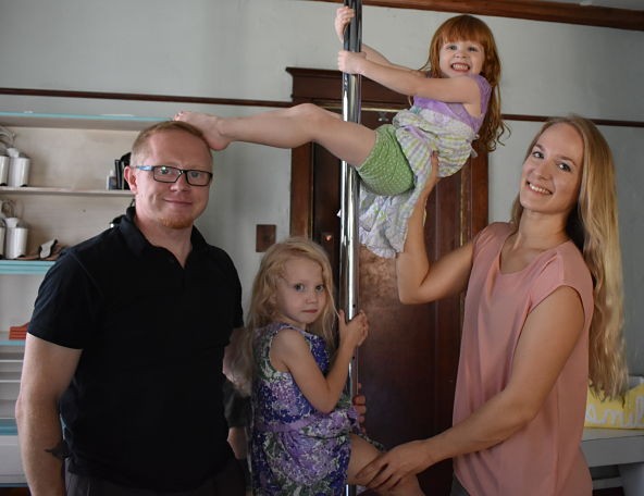 Lindsey Teall and Jake Night with five-year-old Laura and three-year-old Roslyn and the family's living-room pole. - DANIEL HILL