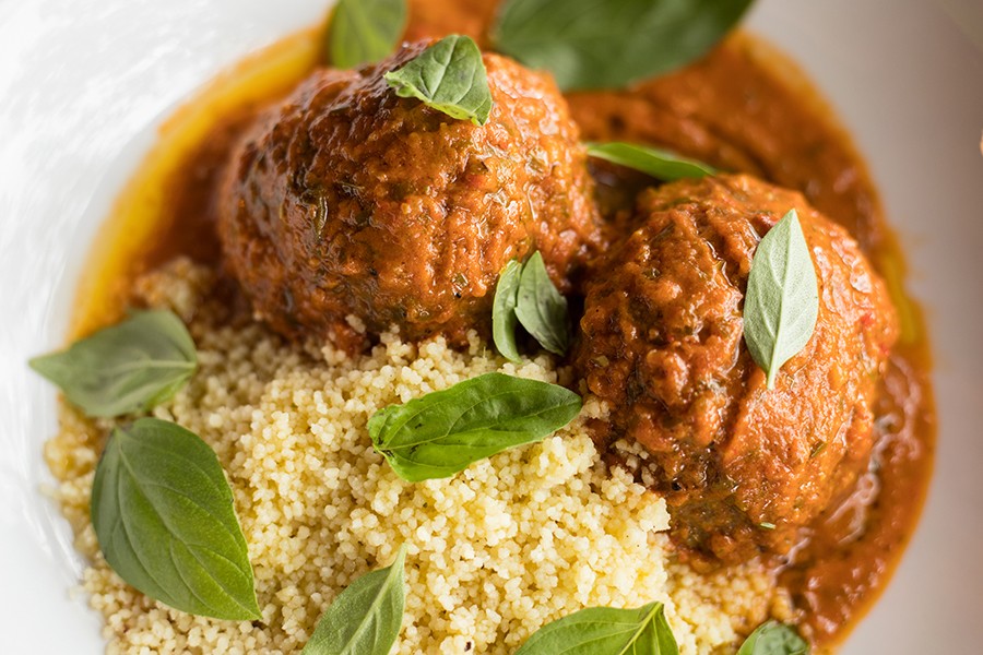 Lamb meatballs are served with smoked tomato sauce, ras el hanout and couscous. - MABEL SUEN