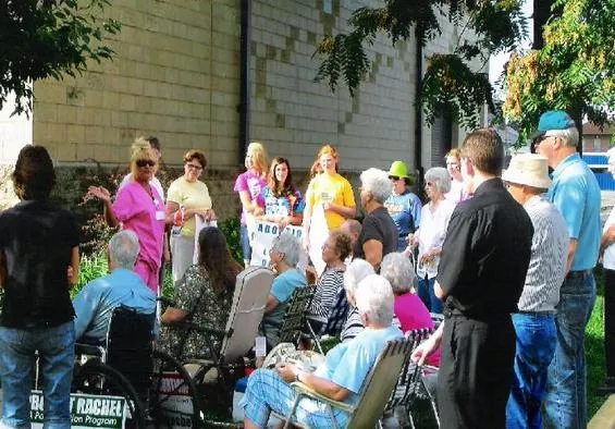 Angela Michael speaks to protestors outside Hope Clinic. Notice the Project Rachel sign in the lower left corner. - Small Victories Ministries