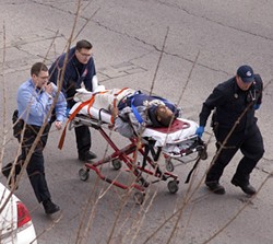 The alleged gunman is wheeled to an ambulance today at roughly 2:20 p.m. - Josh Rowan