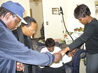 Cookie Thornton's family prays in their home the day after the shootings.