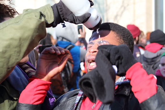 A protester flushes out his eyes after being pepper sprayed by police.