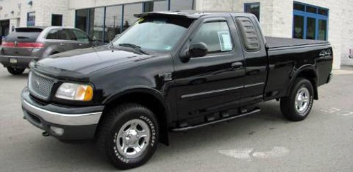 A black 1999 Ford F-150 extended cab pickup truck.