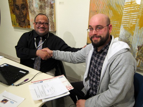 James Lovings, a CAASTL counselor, signs Tim Rakel (R) up for health insurance. - VLAA