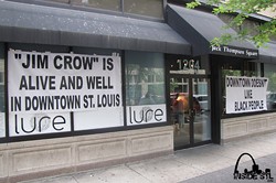 Lure responds yesterday with signs accusing the city of racism. - insidestl.com