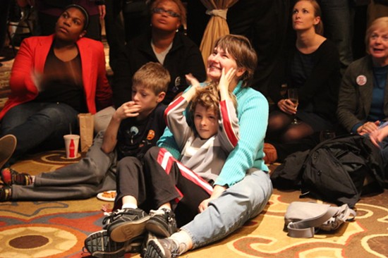 Michael Jones in a blue shirt, and Daniel in his mother's lap. - Leah Greenbaum