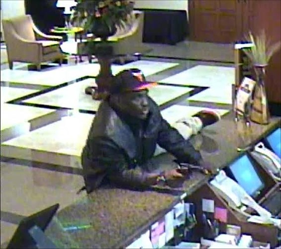 This still from the Drury Inn & Suites security camera footage shows the suspect who shot and killed a night manager. Police say the man was wearing a Chicago Bulls ball cap, a black or brown leather waist-length coat, a black tee shirt with white "Adidas" logo across the front and khaki pants. - SLMPD