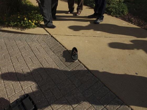 St. Louis detectives gather near one of Yongsang Soh's shoes at the scene of his death.