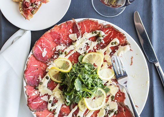 Peppered beef carpaccio, a thinly sliced beef fillet with mustard dressing, arugula, shaved parmesan, capers and lemon. | Jennifer Silverberg