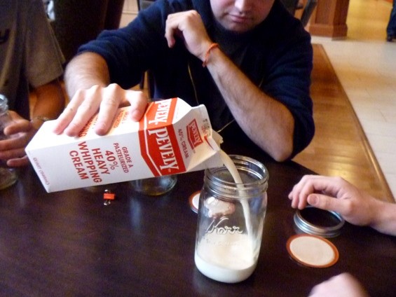Jeremy Winer pours the unchurned cream into Mason jars.