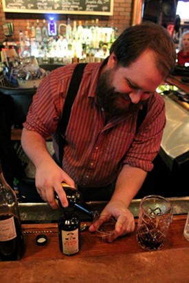 Danno's bartender Jon Hellwig pours a shot for his holiday cocktail. - Mabel Suen