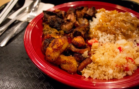 Alloco (fried plantain) and attieke (seasoned couscous-like cassava mixed with tomato, onion and hot pepper) on a jerk chicken plate. - Mabel Suen