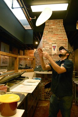 Former culinary manager Dylan Watson tosses a pizza. - Ettie Berneking