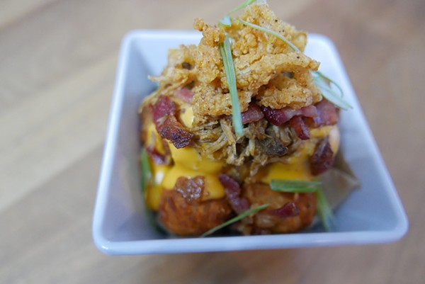 "The Loaded Pucks" are tater tots covered in beer cheese sauce, pulled pork, bacon, and fried onions. - DESI ISAACSON