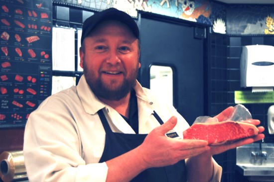 A butcher at the Webster Groves Straub's location holding a cut of prime strip. - CAILLIN MURRAY