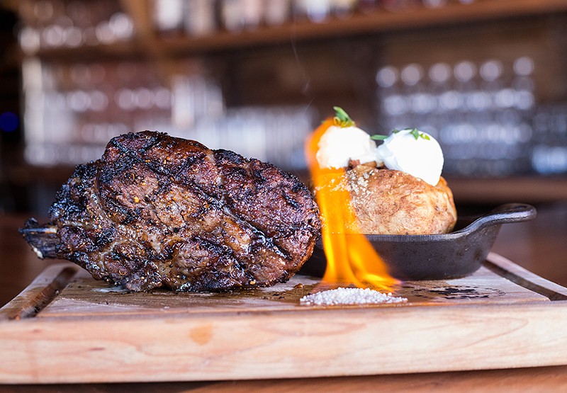 Superior steaks include a 22-ounce bone-in ribeye, shown here with a loaded baked potato. - MABEL SUEN