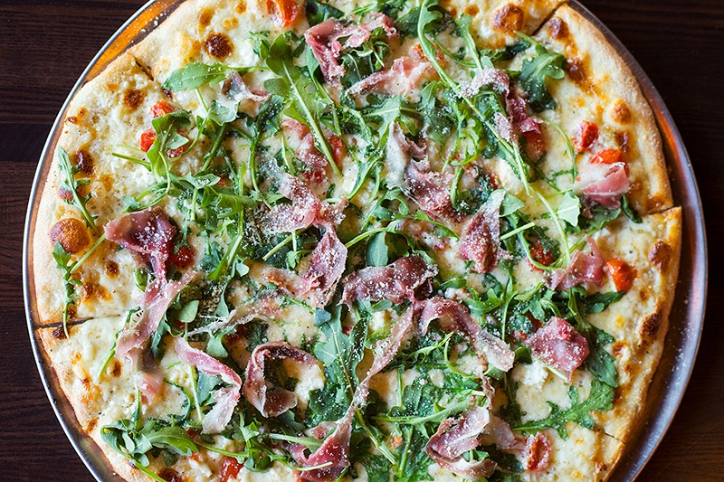 The “Prosciutto and Arugula Bianca” pizza features a rich white sauce topped with prosciutto, arugula, cherry tomatoes, olive oil and shredded fontina cheese. - MABEL SUEN
