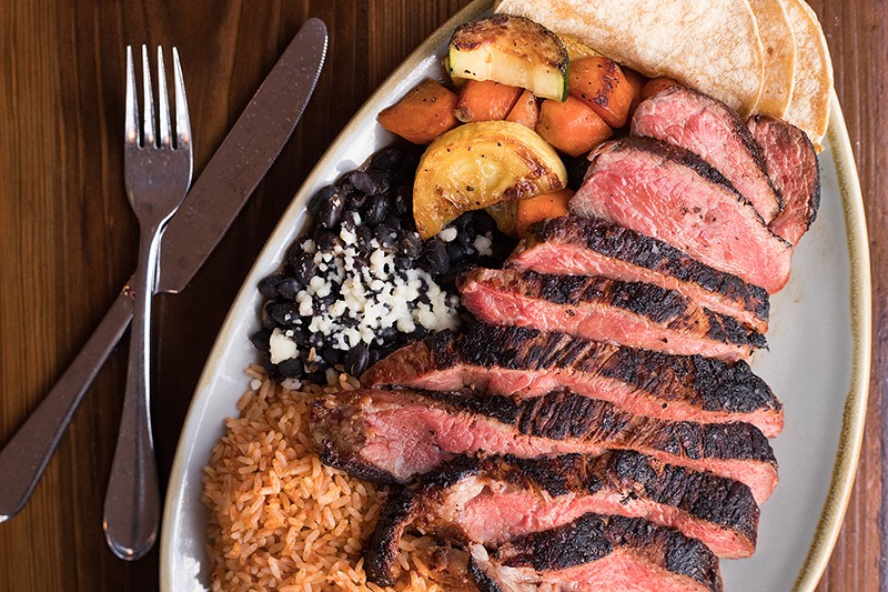 The ribeye, a highlight of Barrio’s menu, has a wonderfully seasoned exterior and is served with rice and beans. - MABEL SUEN
