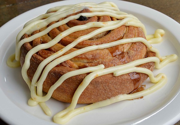 The "XL Cinnamon Roll" has raisins and pecans baked inside. On top is orange cream cheese icing. - TOM HELLAUER