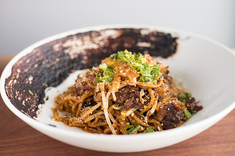 Braised short-rib garlic noodles include black garlic, roasted chiles and togarashi gremolata. - MABEL SUEN