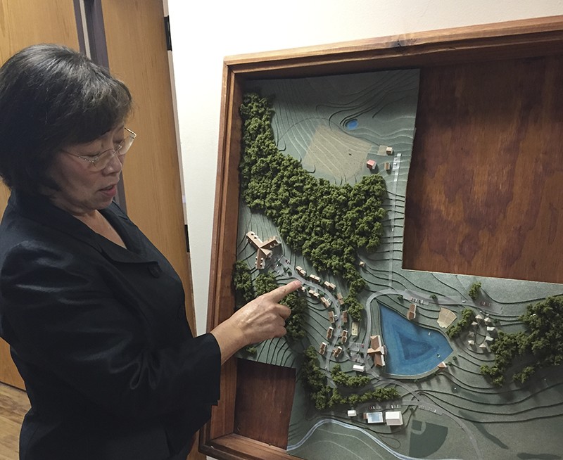 Minji Stark shows off a plan for Peace Village. - PHOTO BY ERIC BERGER