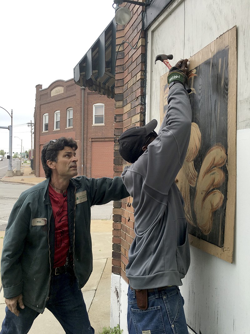 Berwick's technique frequently involves painting pieces on plywood, then hammering and nailing them to buildings. - PHOTO BY THOMAS CRONE