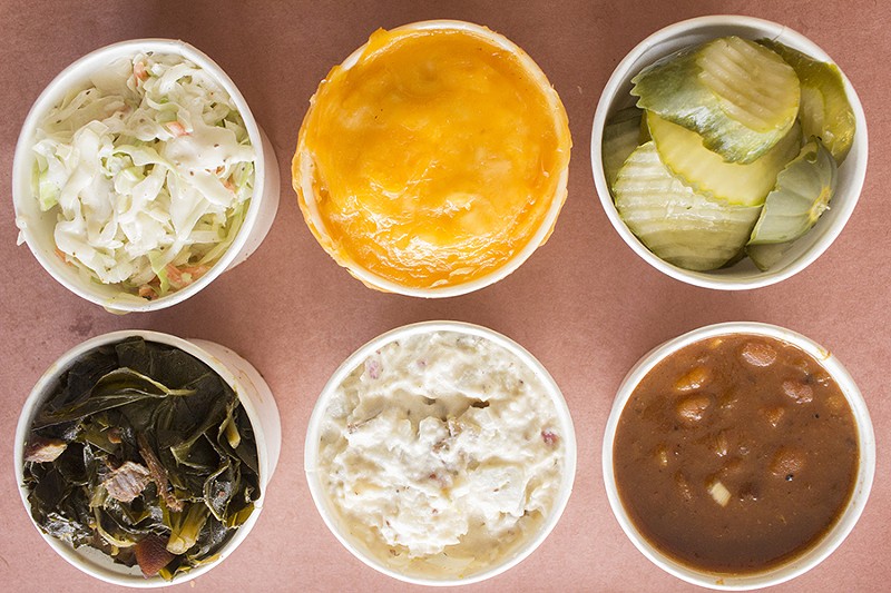 A selection of sides at Big Baby Q and Smokehouse, including greens, slaw and pickles. - PHOTO BY MABEL SUEN