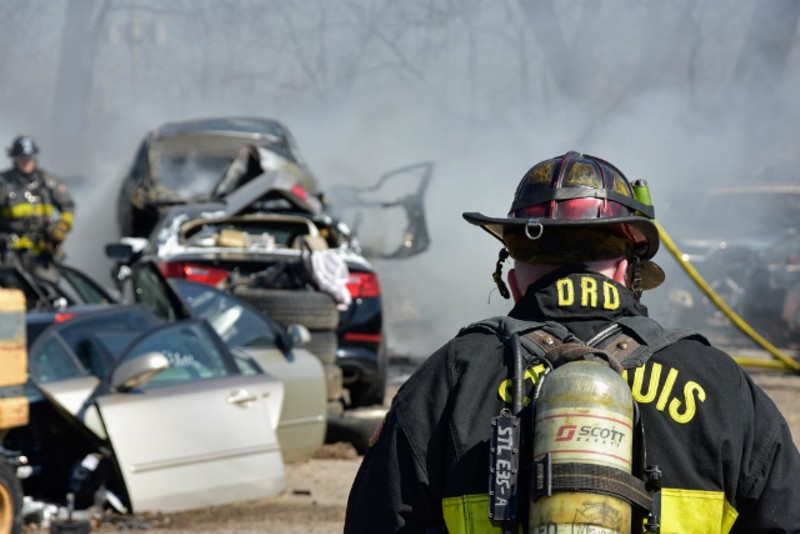 St. Louis firefighters work to put out cars in a salvage yard near Manchester Avenue. - DOYLE MURPHY
