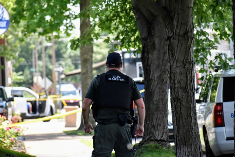 A U.S. Marshal walks toward a police staging area in Tower Grove South. - DOYLE MURPHY