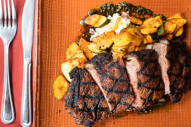 The Steak 55 plates a twelve-ounce grilled New York strip with white cheddar potatoes, chimichurri, seasonal vegetables and veal jus. - MABEL SUEN