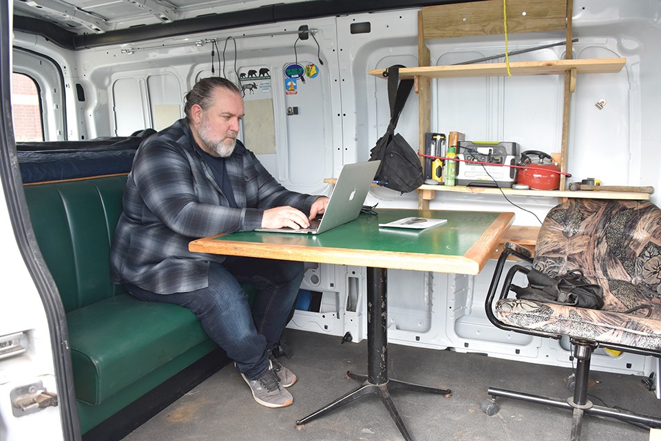 Joshua Rowan’s home office away from home: a rugged and well-traveled Ford van. - DOYLE MURPHY