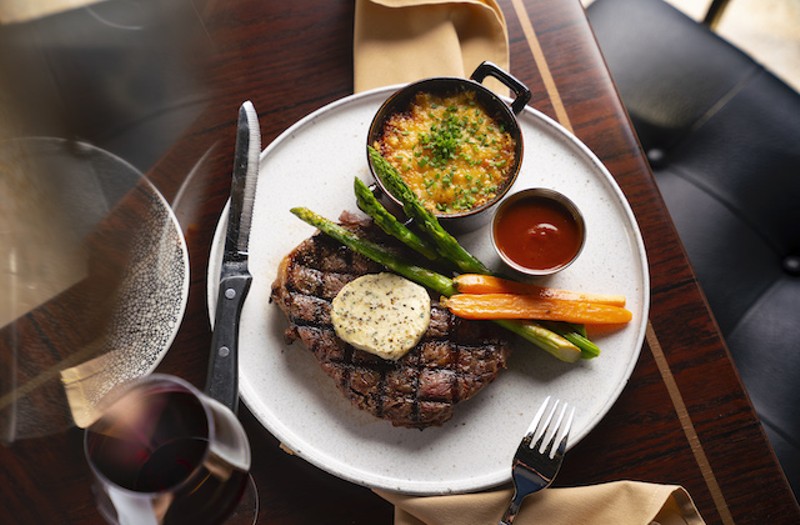 Twelve-ounce ribeye with au gratin potatoes. asparagus, carrots and housemade steak sauce. - Courtesy of Lodging Hospitality Management