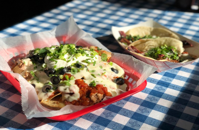 Pulled pork nachos topped with queso, sour cream, Esther's beans, black olives and green onions. - LIZ MILLER