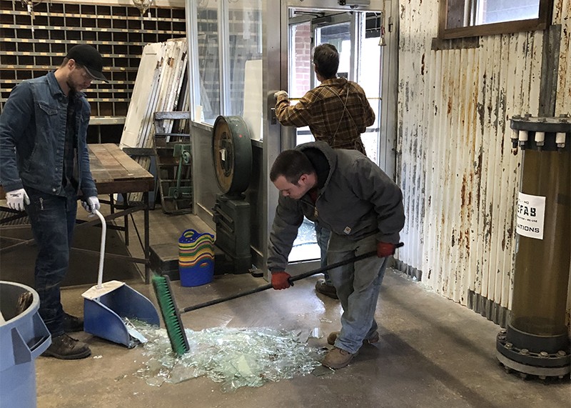 Refab workers clean up glass from a Monday morning break-in. - COURTESY OF ERIC SCHWARZ